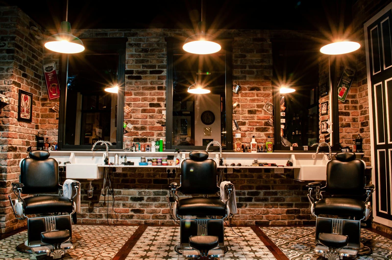 Sillones de barbería frente a espejos y lámparas