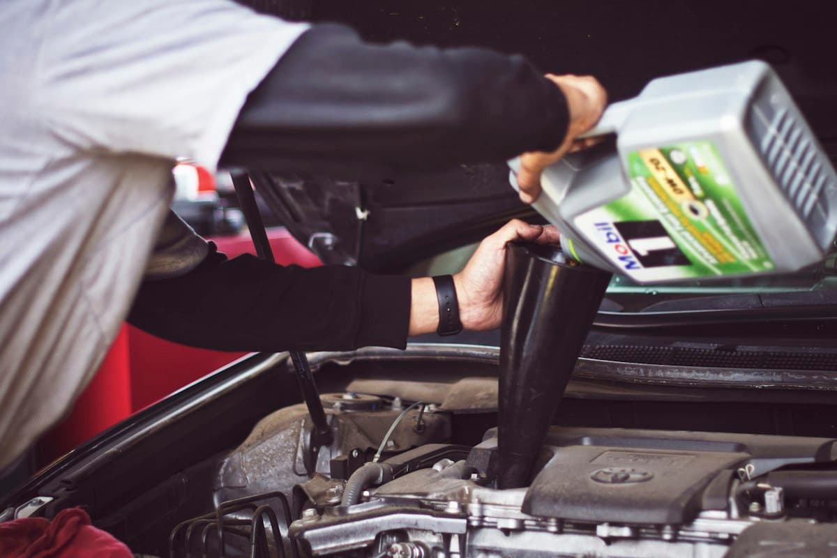 Mecánico trabajando en el motor de un auto dentro del taller